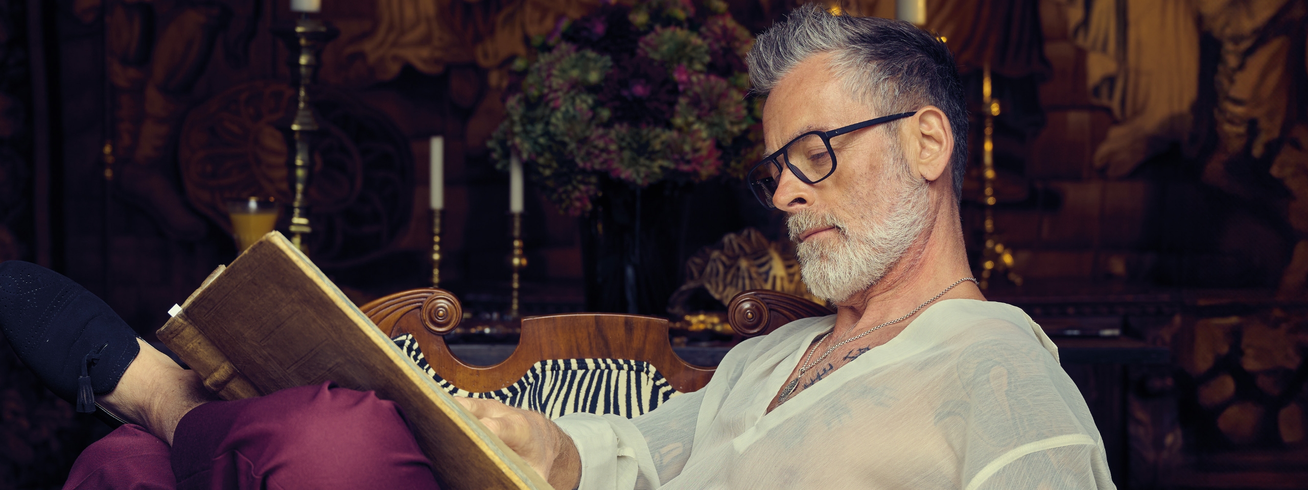 Älterer Mann mit Gleitsichtbrille liest ein Buch.